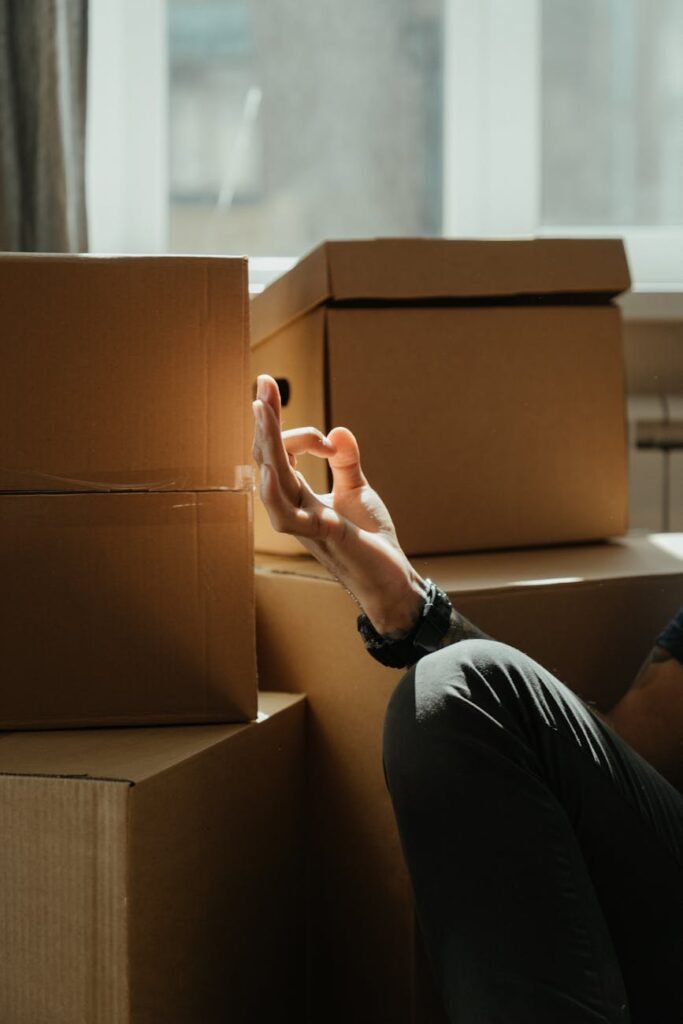 person in black long sleeve shirt holding brown cardboard box