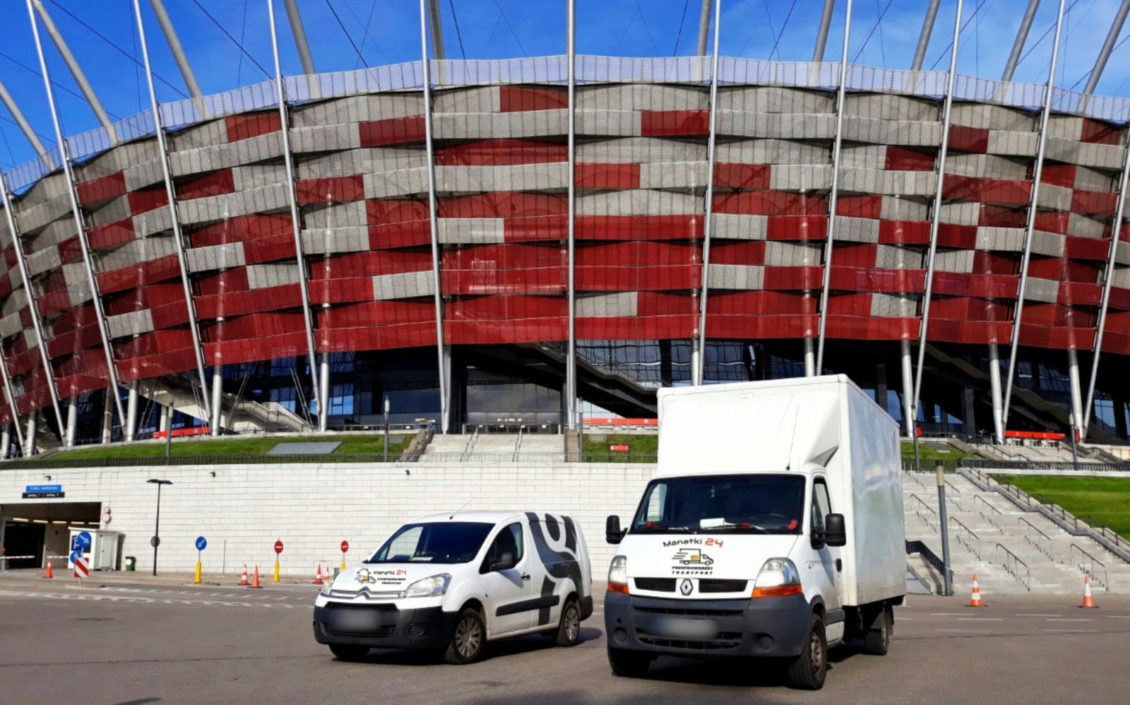 Two trucks parked in front of a large building