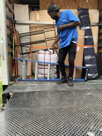 Mover securing wrapped furniture and household items inside a truck
