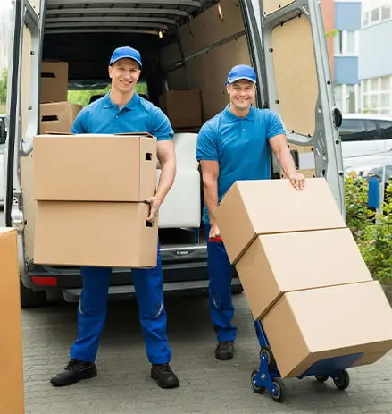 Two professional movers unloading cardboard boxes from a moving van