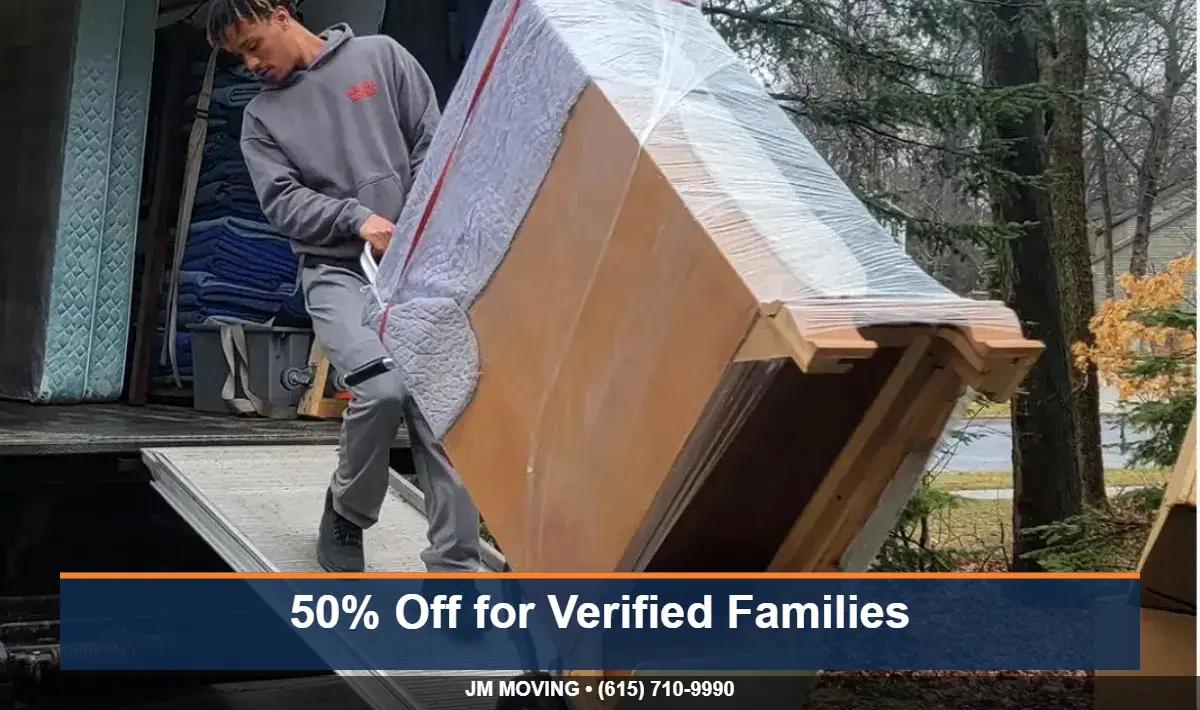 JM Moving mover rolling wrapped furniture on a dolly in Nashville